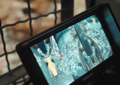 Brigade monitor gemonteerd in een wiellader die een 360-graden zicht rondom het voertuig toont in een recyclingcentrum.