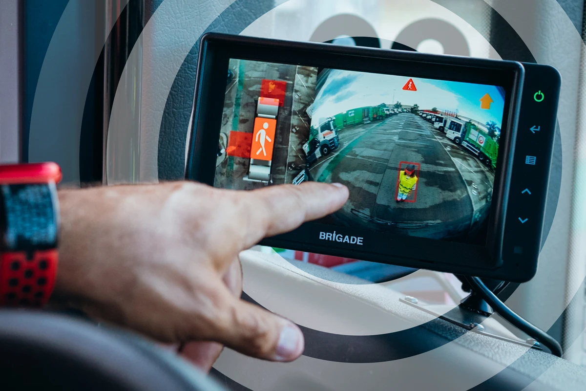 Le conducteur montre du doigt une personne détectée sur un moniteur installé à l'intérieur de son véhicule.