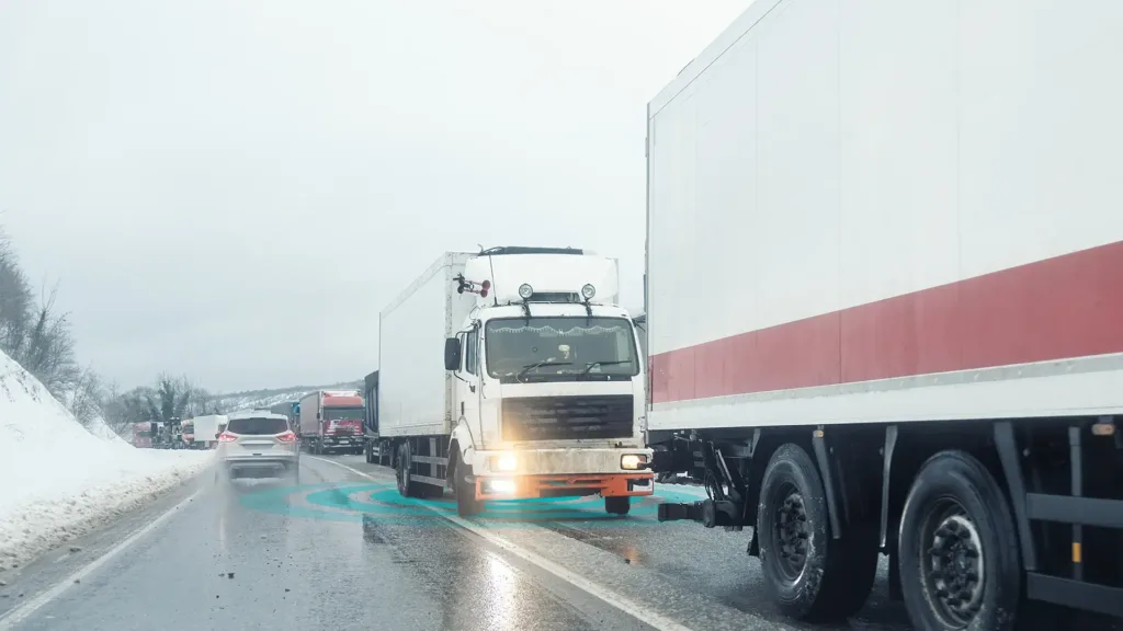 Autoarticolato in coda nel traffico su un'autostrada ghiacciata in condizioni di neve.