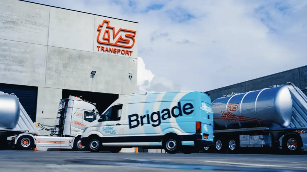 Un fourgon de présentation Brigade garé devant les locaux de TVS Transport, à côté des camions