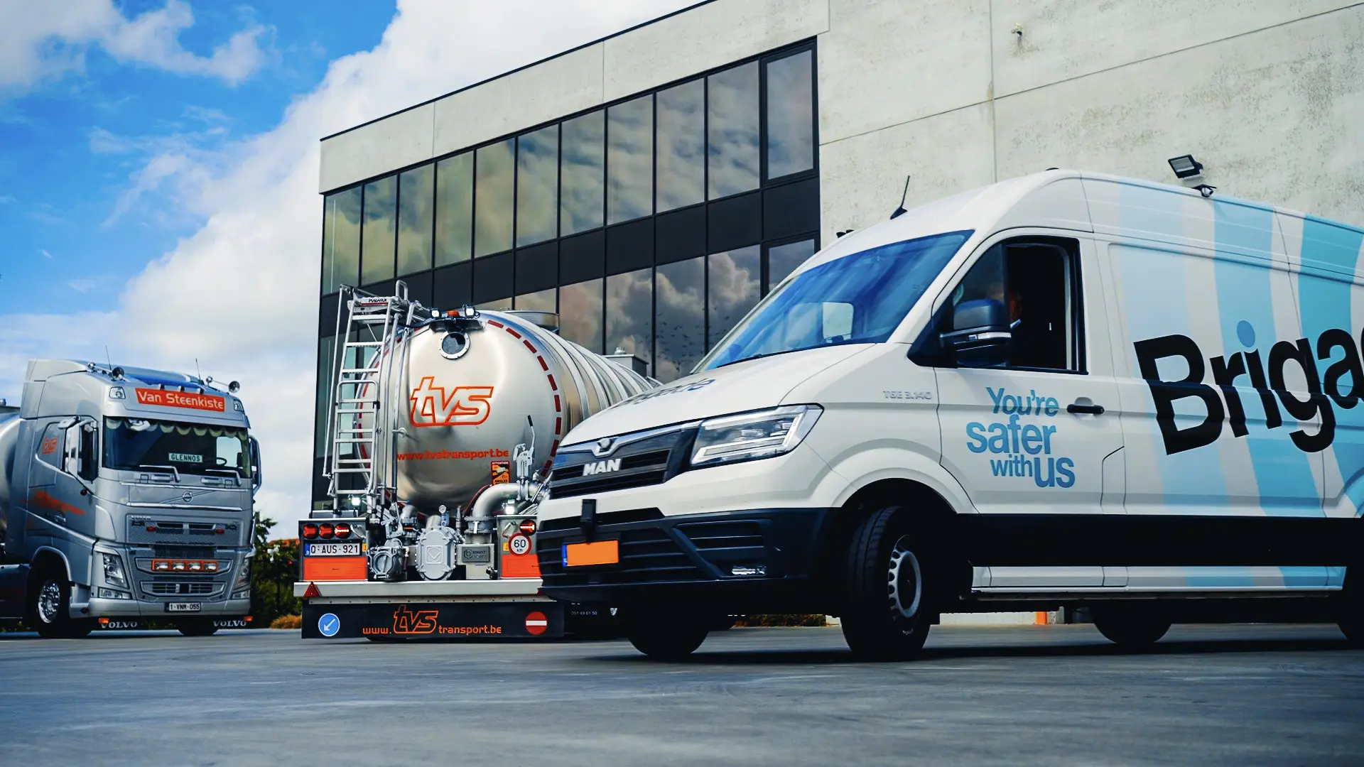 Un fourgon de présentation Brigade garé devant les locaux de TVS Transport, à côté des camions