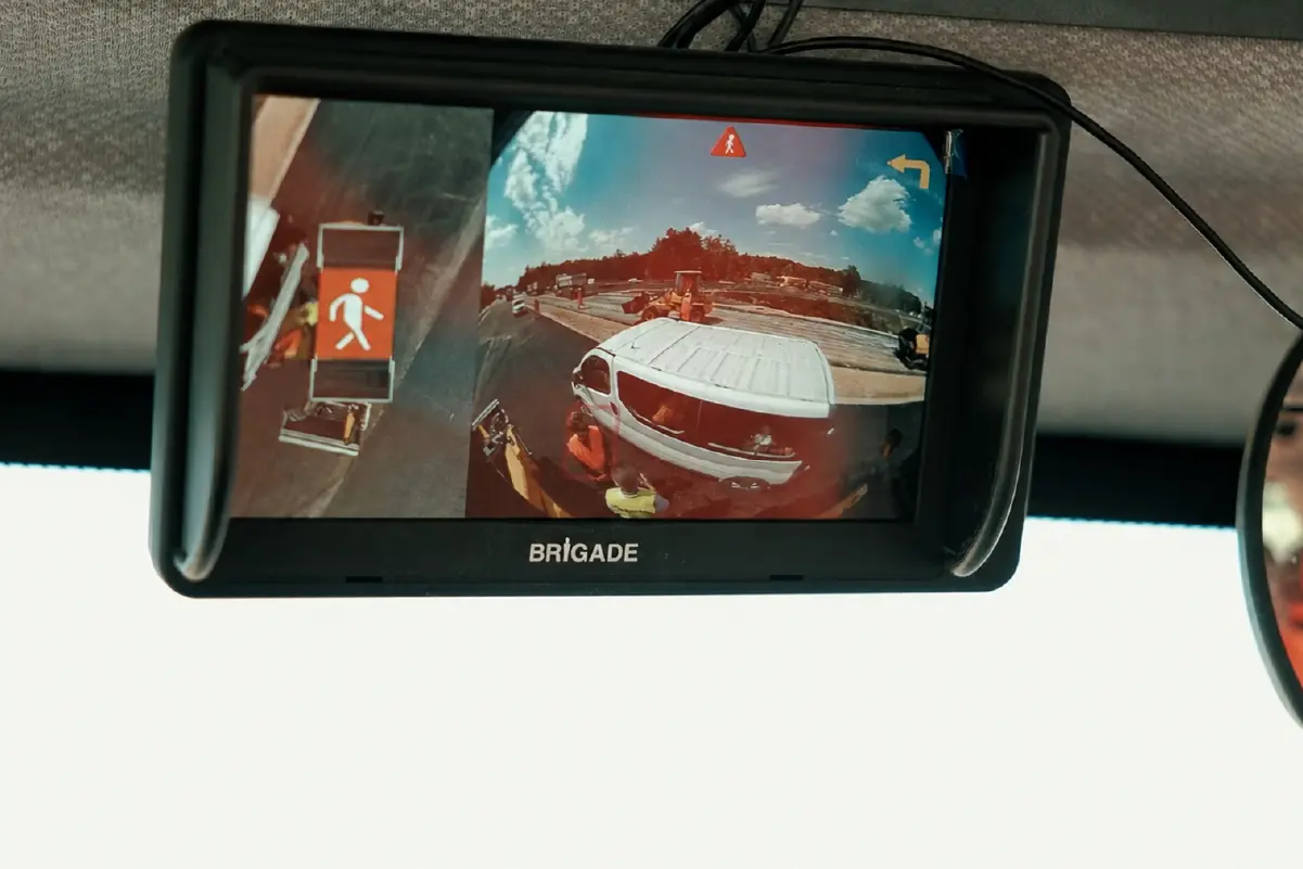 budimex-brigade-10-1200px A Brigade monitor inside a road roller cabin showing a 360-degree view and a person being and van detected in the vehicle's blindspot.