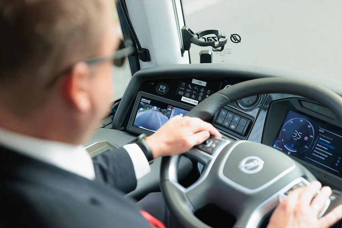 Een Brigade-monitor in de cabine van een wegwals die een 360-gradenbeeld weergeeft en laat zien dat er een persoon en een bestelwagen in de dode hoek van het voertuig zijn gedetecteerd.