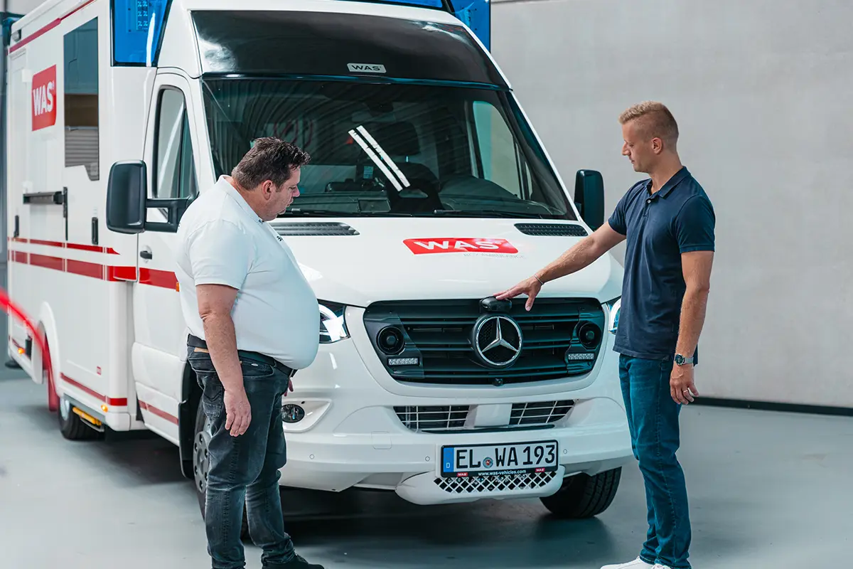 Brigade Backeye®360 AI fitted to front of ambulance with two workers discussing it.